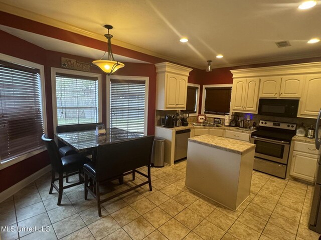 kitchen with ornamental molding, stainless steel appliances, sink, a center island, and hanging light fixtures
