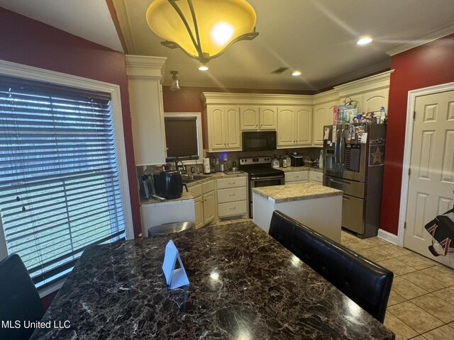 kitchen featuring stainless steel fridge, backsplash, plenty of natural light, and range with electric stovetop