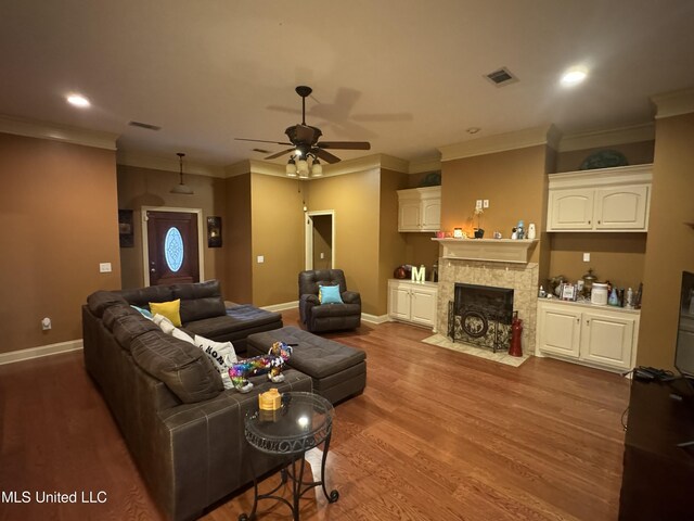 living room featuring ceiling fan, hardwood / wood-style floors, a high end fireplace, and ornamental molding