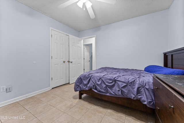 bedroom featuring a textured ceiling, light tile patterned flooring, and ceiling fan