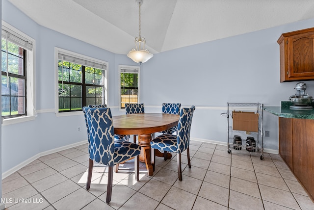 tiled dining room featuring vaulted ceiling