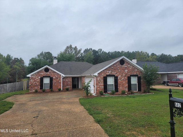 ranch-style home featuring brick siding, a front lawn, fence, a chimney, and driveway