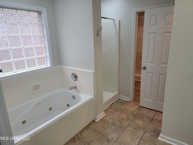 bathroom featuring a spacious closet, a stall shower, a whirlpool tub, and tile patterned flooring