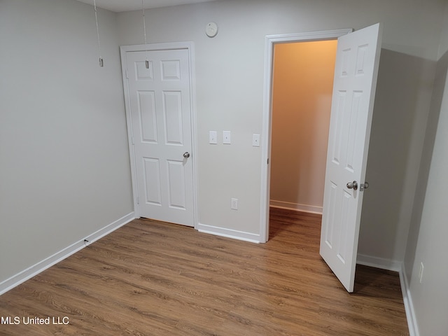 unfurnished bedroom featuring baseboards and wood finished floors