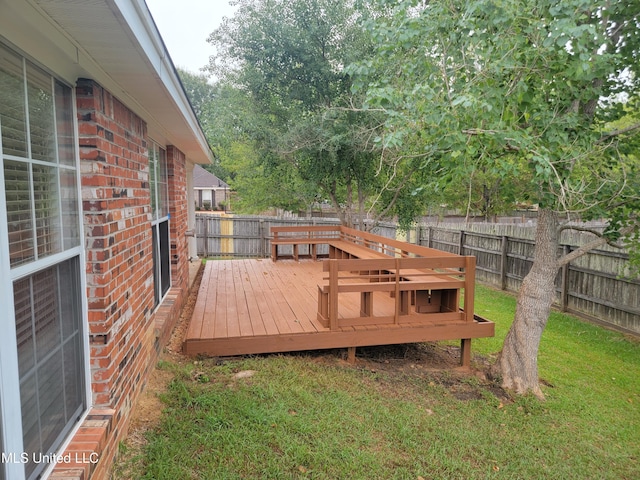 wooden deck with a yard and a fenced backyard