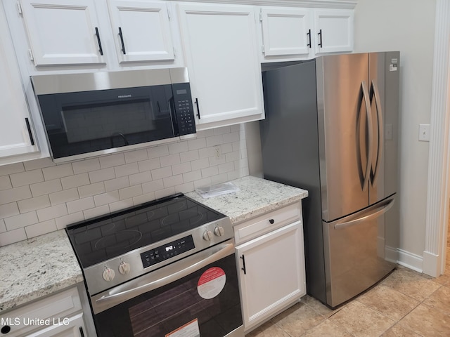 kitchen featuring light stone counters, decorative backsplash, appliances with stainless steel finishes, and white cabinetry