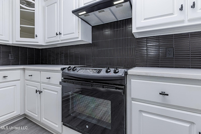 4954 Brookwood Pl, Byram, MS 39272 - kitchen featuring black range with electric cooktop, extractor fan, white cabinetry, light countertops, and glass insert cabinets
