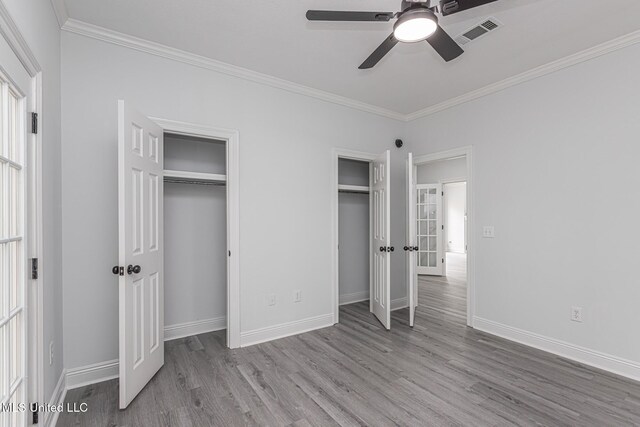 4954 Brookwood Pl, Byram, MS 39272 - unfurnished bedroom with multiple closets, wood finished floors, ornamental molding, and a ceiling fan