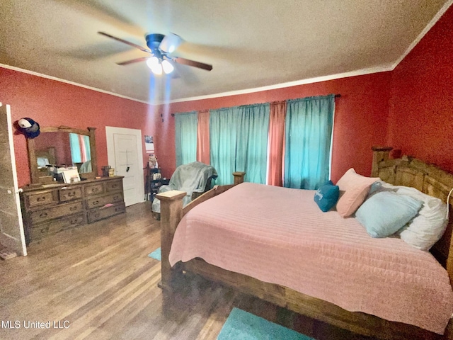 bedroom featuring ceiling fan, wood finished floors, and crown molding