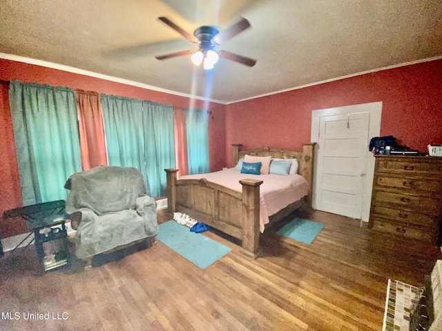 bedroom with wood finished floors, ceiling fan, and ornamental molding