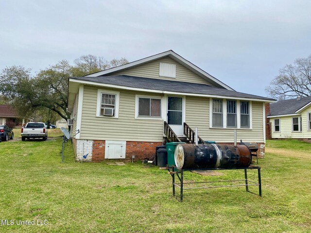 view of front facade featuring a front yard, entry steps, and roof with shingles