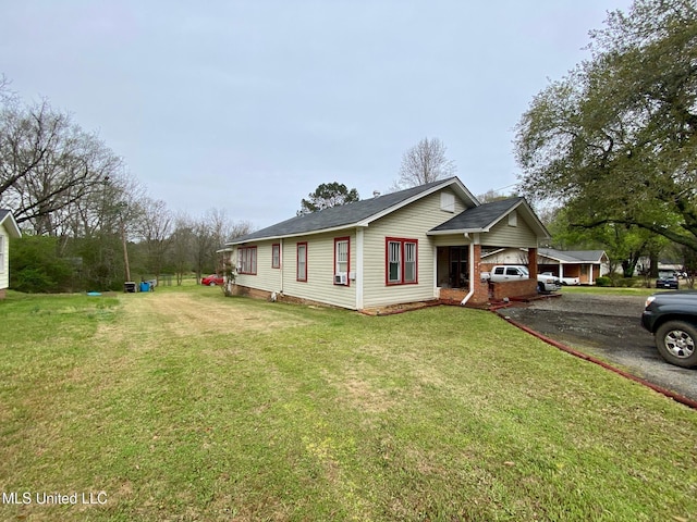 view of front of house featuring brick siding, aphalt driveway, and a front lawn