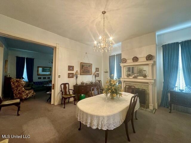 206 Linton Ave, Natchez, MS 39120 - dining area featuring light carpet, a chandelier, and a fireplace with raised hearth