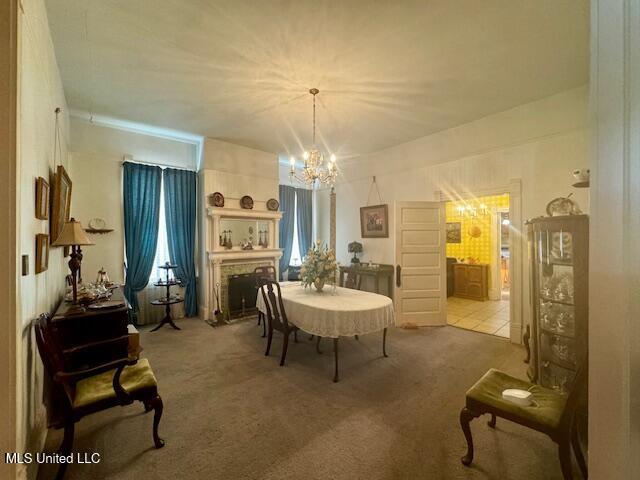 206 Linton Ave, Natchez, MS 39120 - dining room with a chandelier, carpet floors, and a brick fireplace