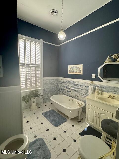 206 Linton Ave, Natchez, MS 39120 - full bathroom with wainscoting, toilet, tile patterned floors, a freestanding tub, and tile walls