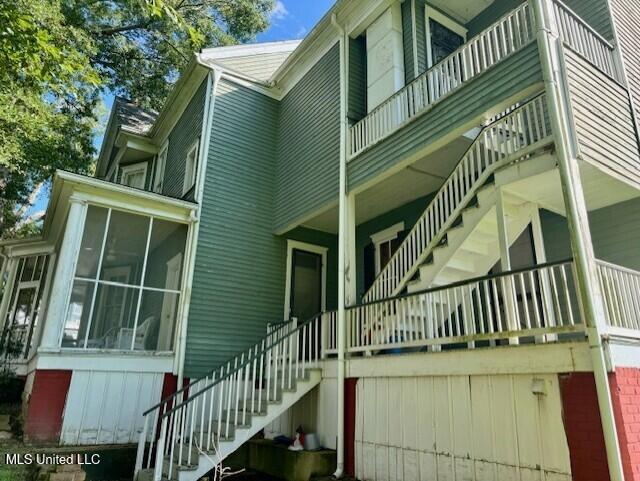 206 Linton Ave, Natchez, MS 39120 - view of home's exterior featuring stairway, a sunroom, a balcony, and a garage