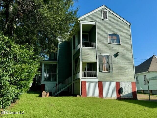 206 Linton Ave, Natchez, MS 39120 - back of property featuring a balcony, a lawn, stairway, and a sunroom