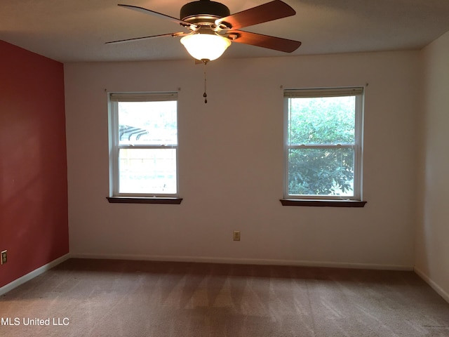 carpeted spare room featuring ceiling fan