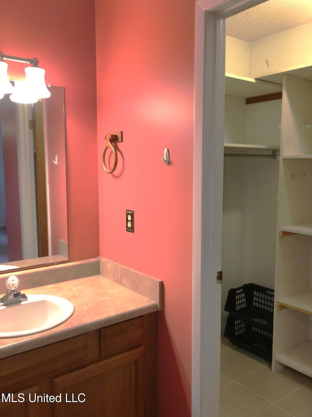 bathroom featuring tile patterned floors, vanity, and a textured ceiling