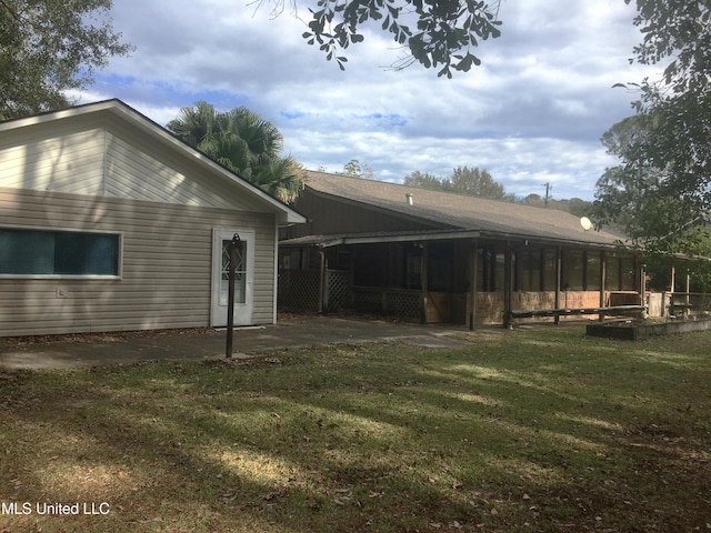 back of house featuring a yard and a sunroom