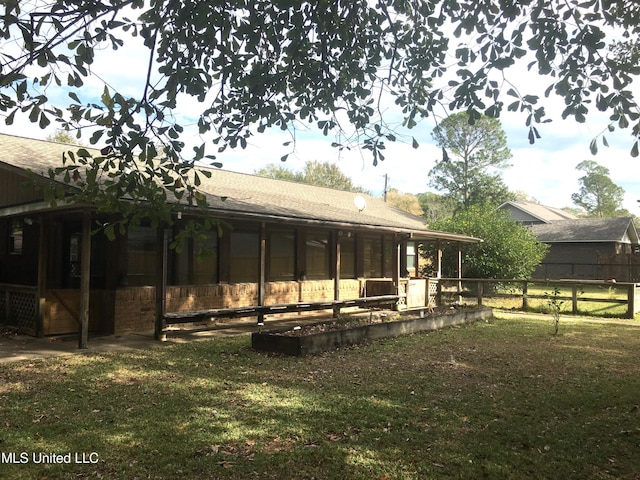 back of house with a sunroom and a yard