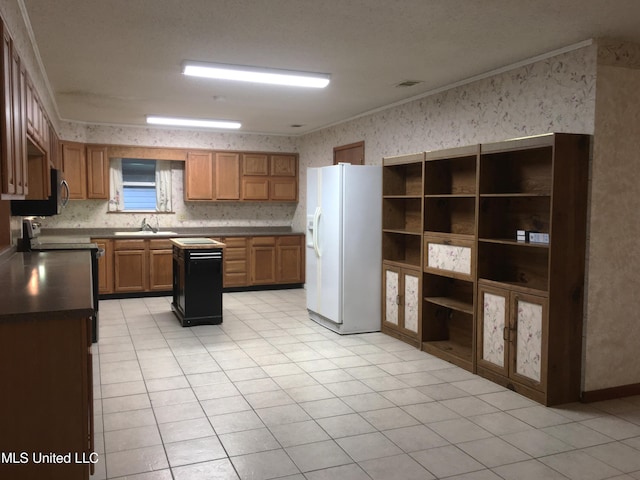 kitchen with ornamental molding, sink, white refrigerator with ice dispenser, light tile patterned floors, and a center island