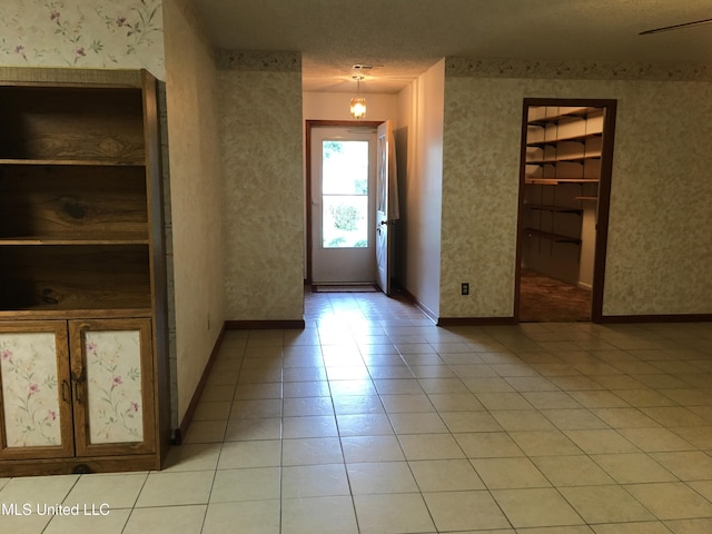 entrance foyer featuring a textured ceiling and light tile patterned flooring