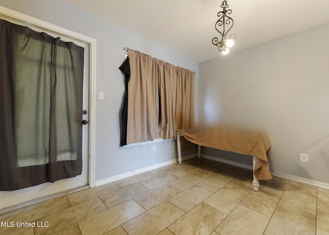 unfurnished bedroom featuring light tile patterned floors and baseboards