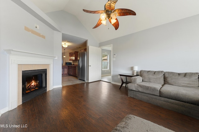 living room featuring high vaulted ceiling, a ceiling fan, light wood-style floors, a fireplace, and baseboards