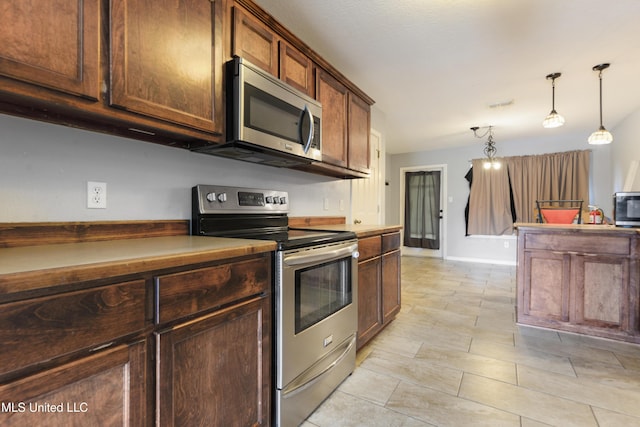 kitchen with hanging light fixtures, visible vents, and appliances with stainless steel finishes