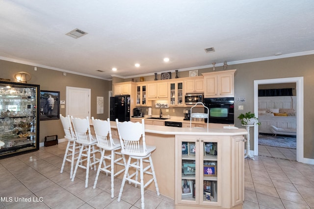 701 S Hill Ct, Biloxi, MS 39532 - kitchen with black appliances, light tile patterned floors, ornamental molding, a large island with sink, and light countertops