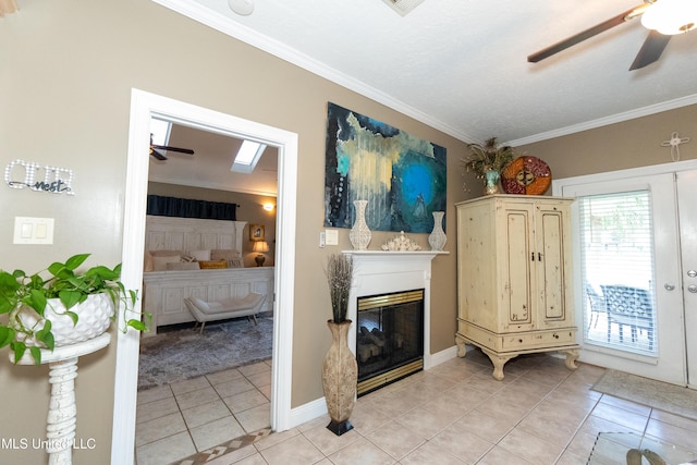 701 S Hill Ct, Biloxi, MS 39532 - living room with ceiling fan, light tile patterned flooring, ornamental molding, and a glass covered fireplace
