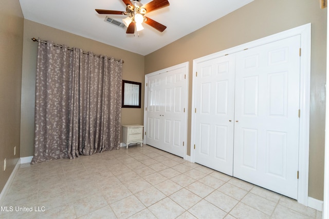 701 S Hill Ct, Biloxi, MS 39532 - unfurnished bedroom with two closets, light tile patterned flooring, and ceiling fan