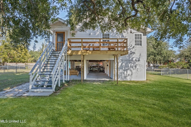 back of house with a lawn, a wooden deck, and a patio