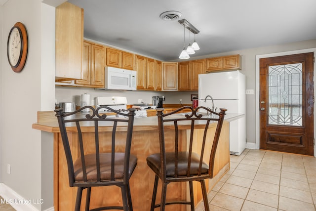 kitchen featuring kitchen peninsula, light tile patterned floors, white appliances, and a breakfast bar