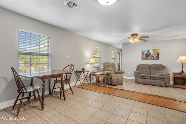 dining space with light tile patterned floors and ceiling fan