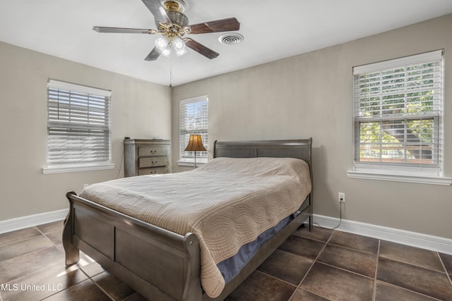 tiled bedroom featuring ceiling fan