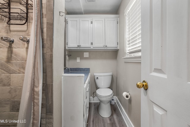 bathroom with curtained shower, wood-type flooring, vanity, and toilet