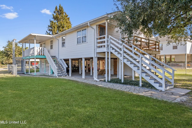 rear view of house featuring a patio, a lawn, and a deck