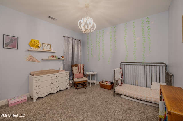 carpeted bedroom featuring a chandelier and a crib