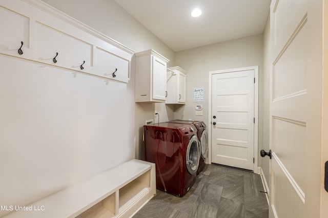 laundry area with separate washer and dryer and cabinets