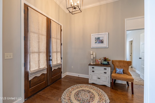 entrance foyer with dark wood-type flooring, ornamental molding, a chandelier, and french doors