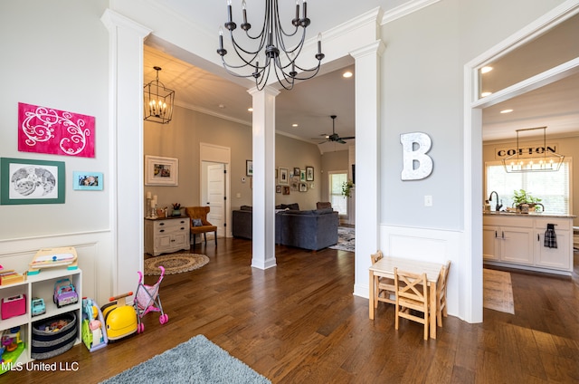 game room featuring ornate columns, crown molding, dark hardwood / wood-style floors, and ceiling fan