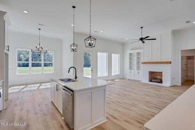 1025 Mullican Rd, Florence, MS 39073 - kitchen with a sink, light wood finished floors, a brick fireplace, white cabinetry, and stainless steel dishwasher