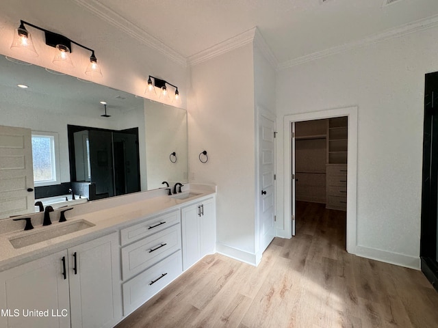 bathroom featuring vanity, hardwood / wood-style floors, a bath, and ornamental molding