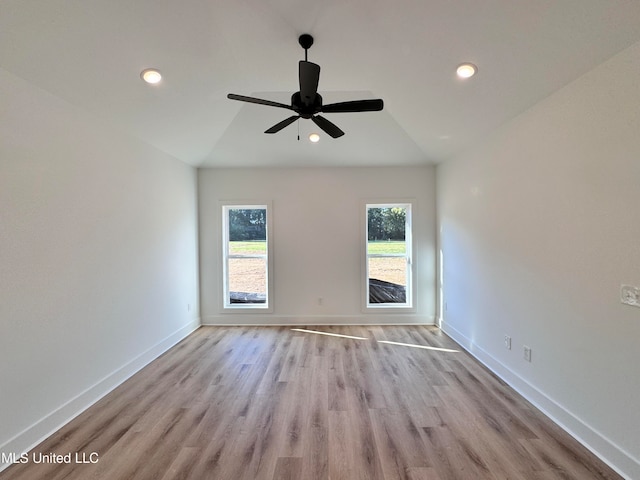 empty room with lofted ceiling, light wood-type flooring, and ceiling fan