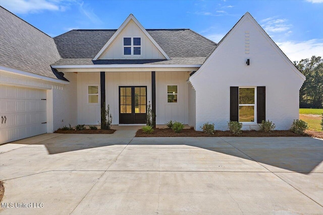 1025 Mullican Rd, Florence, MS 39073 - modern farmhouse with roof with shingles, a garage, board and batten siding, concrete driveway, and french doors