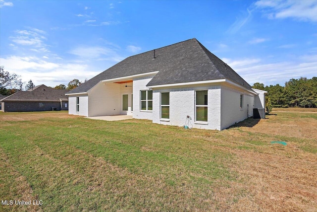 back of property with a yard and a patio