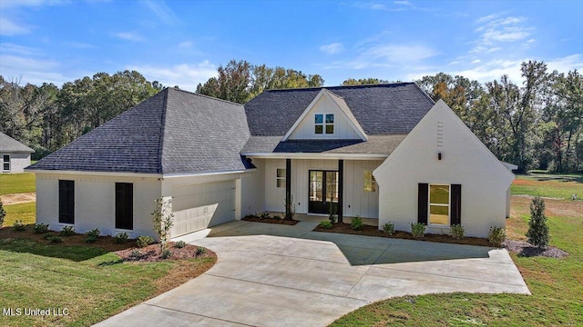 1025 Mullican Rd, Florence, MS 39073 - view of front facade with a garage, a front yard, french doors, a shingled roof, and driveway