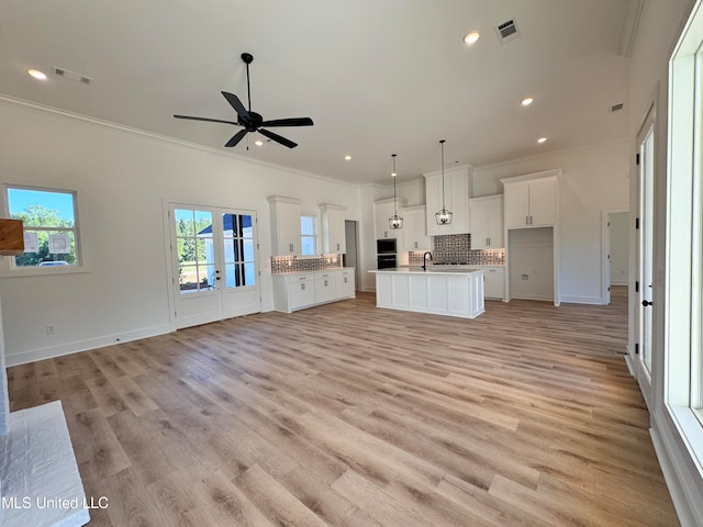 unfurnished living room featuring crown molding, sink, light wood-type flooring, and ceiling fan